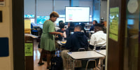 A teacher talks to a student during an African American Studies AP class
